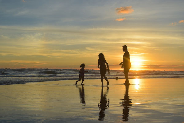 family on beach at sunset